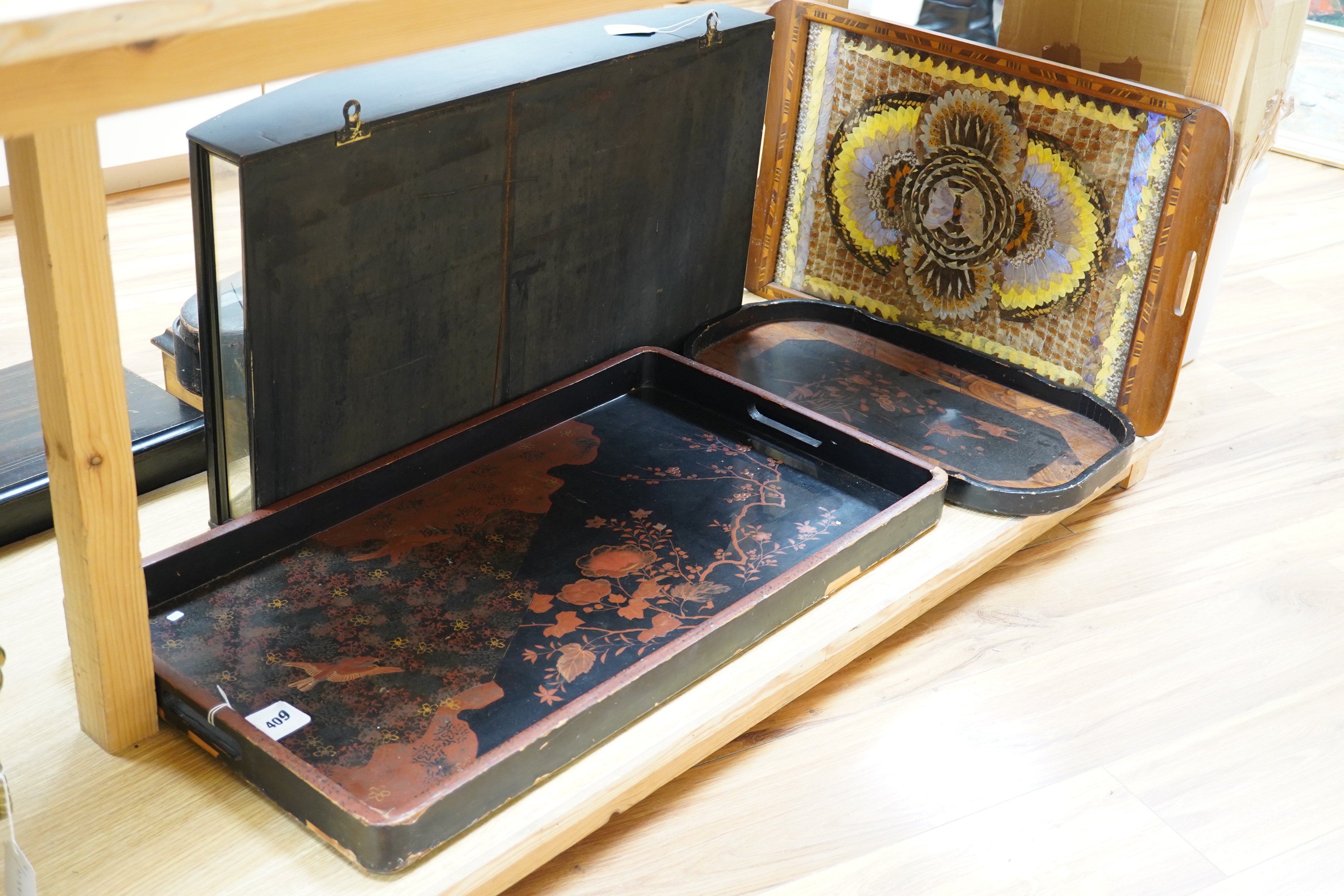 Three trays to include a butterfly wing example and a Japanese lacquered example decorated with birds and flowers, 75cm wide. Condition - poor to fair